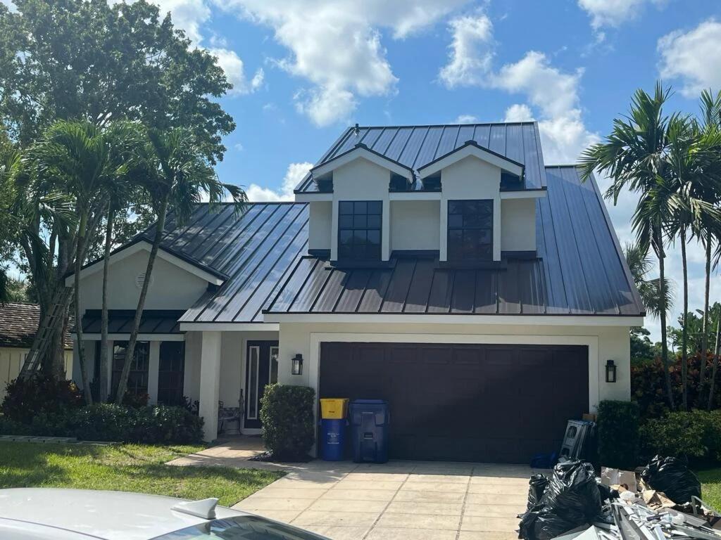 Metal roof on a two-story home with two dormers and several roof slopes.