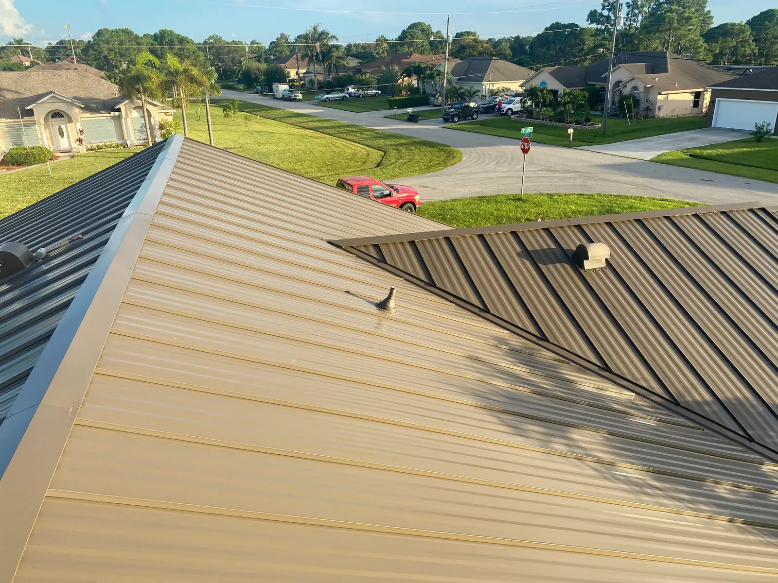 Close view of bronze and dark-brown standing-seam metal roof panels on a residential roof.
