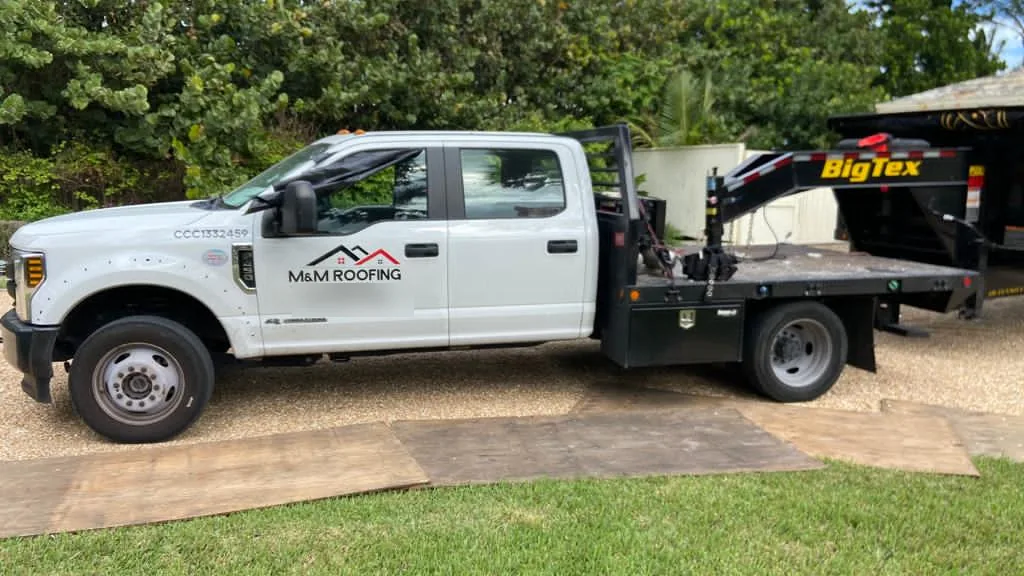 M&M Roofing work truck with a dump trailer prepared for a roofing job.