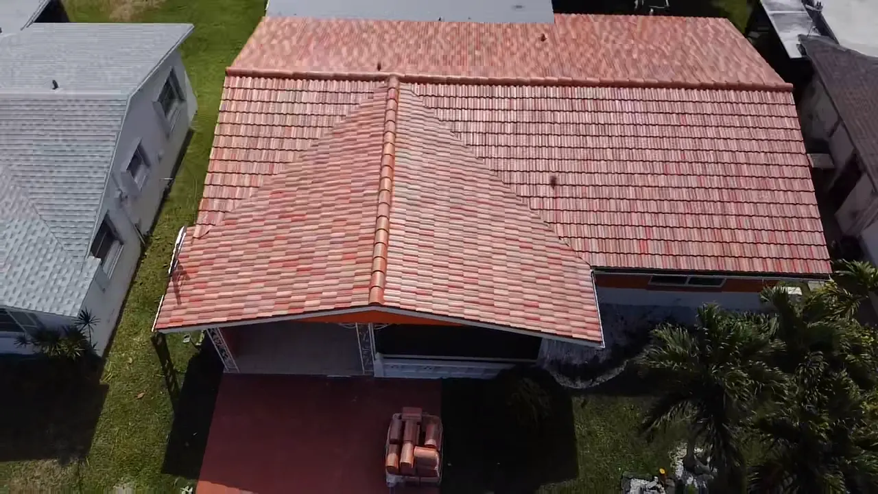 Aerial view of a red tile roof over a single-story home and covered driveway.